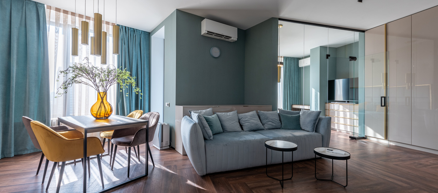 Pièce de vie lumineuse aux murs bleu-gris, montrée sur le site officiel